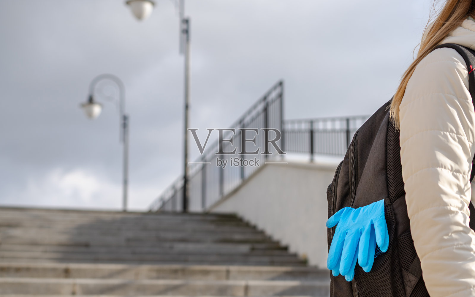 这个女孩戴着医用手套以保护她的手不受病毒感染。个人防护装备。照片摄影图片