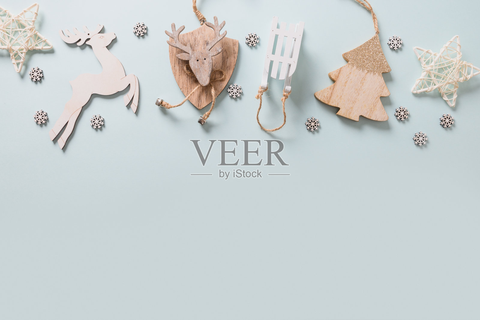 圣诞节日框架与白色DIY木制装饰,鹿,小玩意,礼物,雪花在蓝色的背景。前视图。圣诞贺卡照片摄影图片