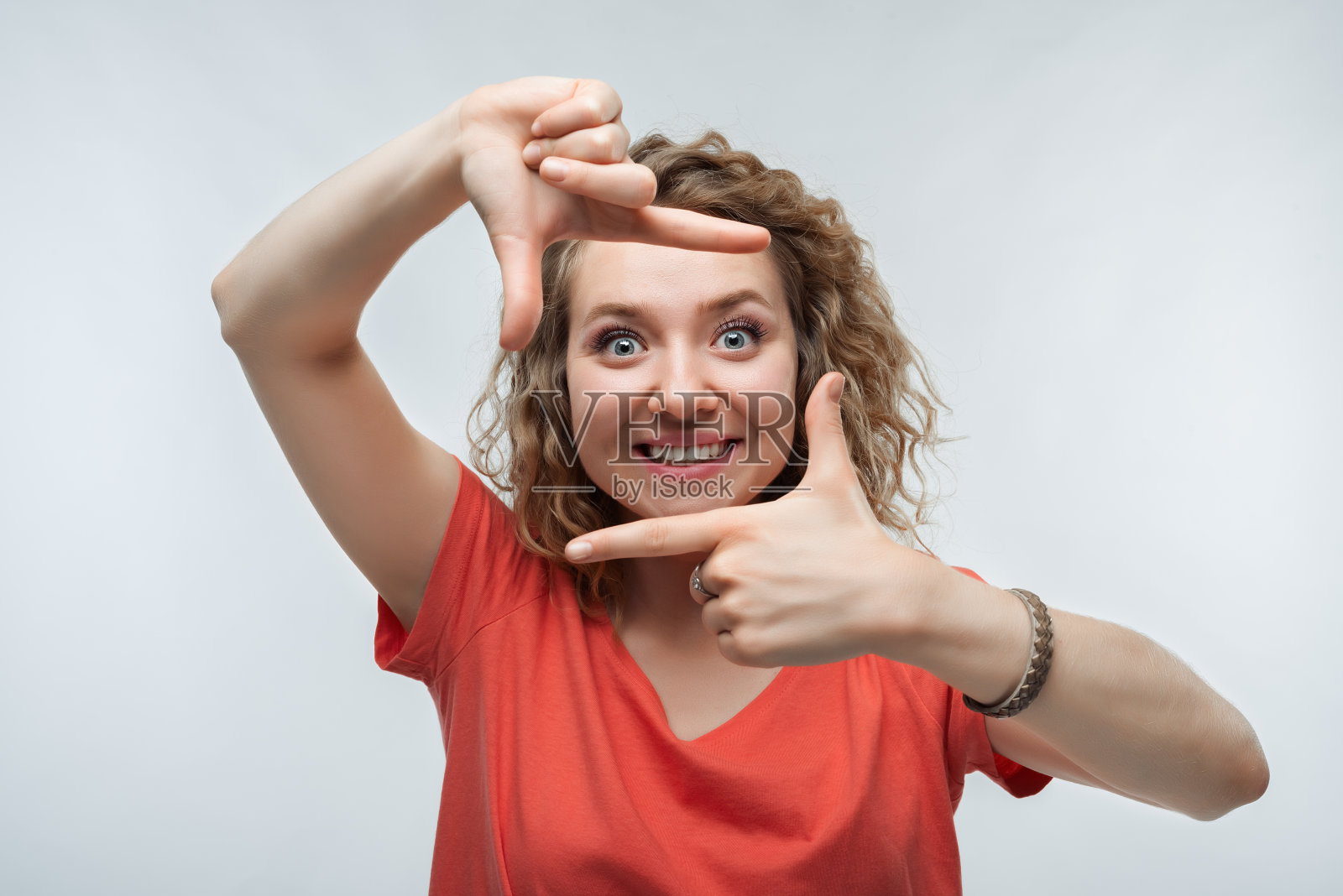 有趣的女人微笑的照片,用手指做相框。人的情绪、表情概念照片摄影图片