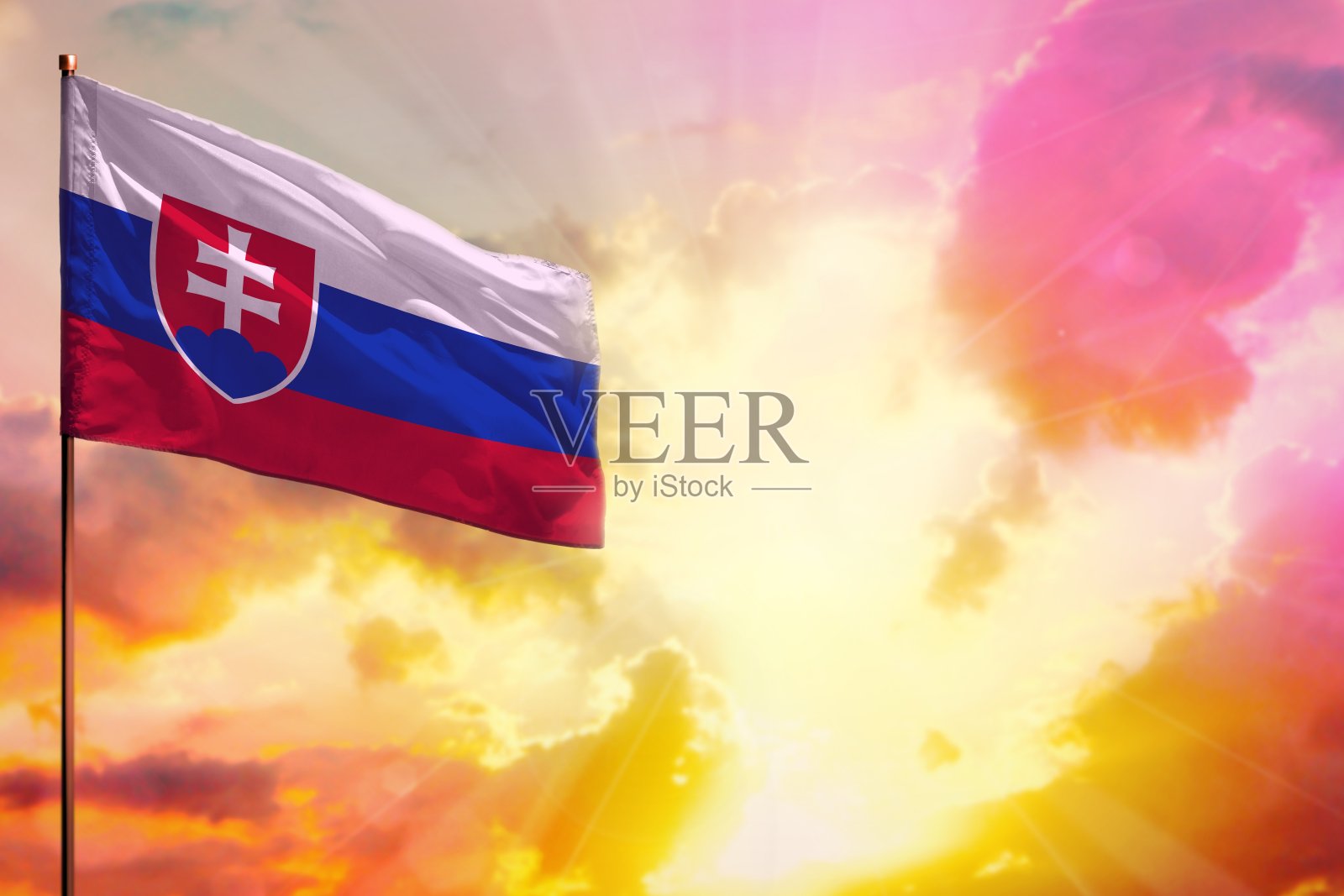 飘扬的斯洛伐克国旗在左上角的模型与您的文字空间美丽的彩色日落或日出的背景。照片摄影图片