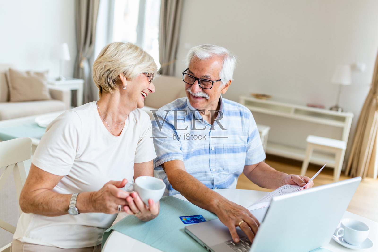 老夫妇微笑着在电脑上查看水电费或保险,方便上网,老年用户使用科技照片摄影图片