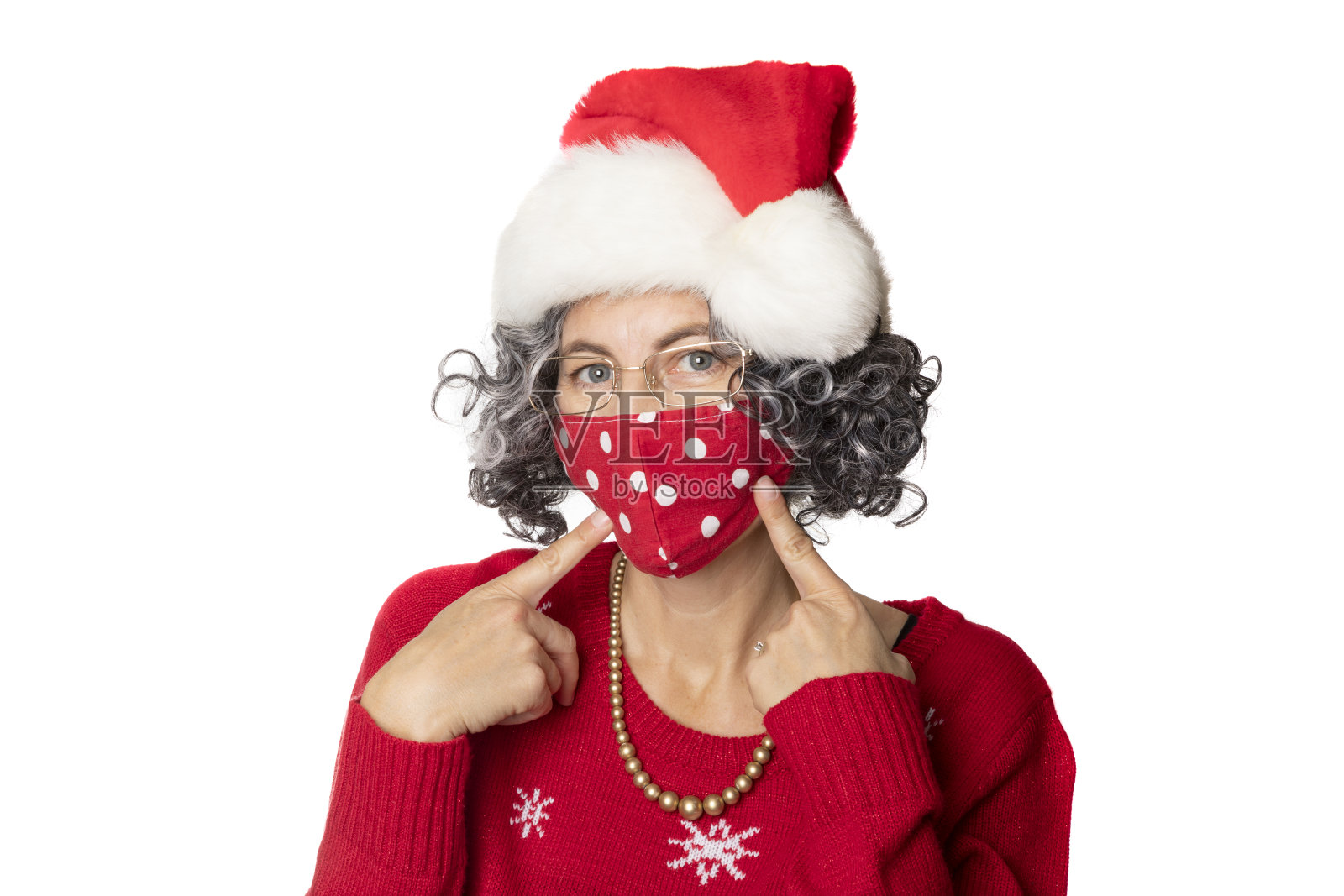 戴圣诞帽的女人指着面具照片摄影图片