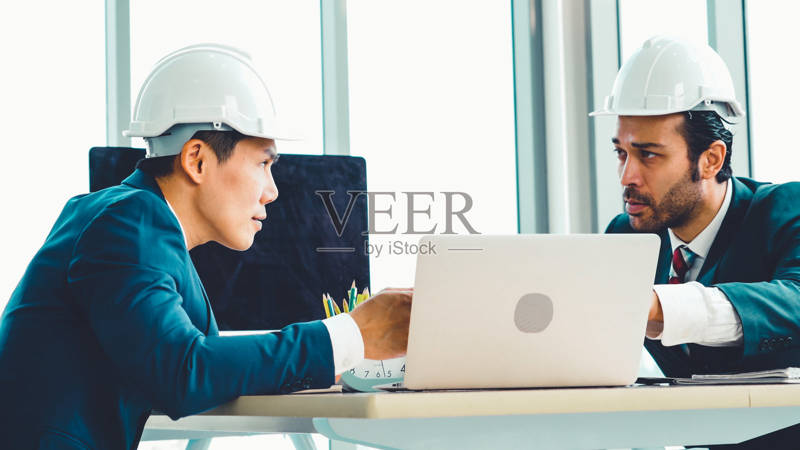 工程师和建筑师在办公桌旁开会照片摄影图片