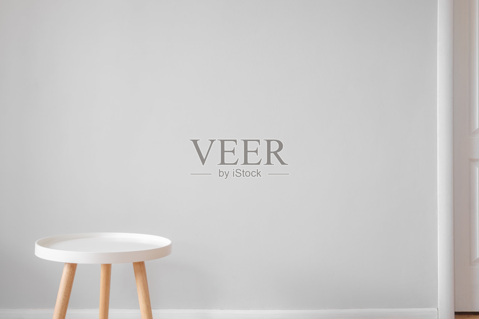 灰色墙壁前空荡荡的白色咖啡桌。照片摄影图片