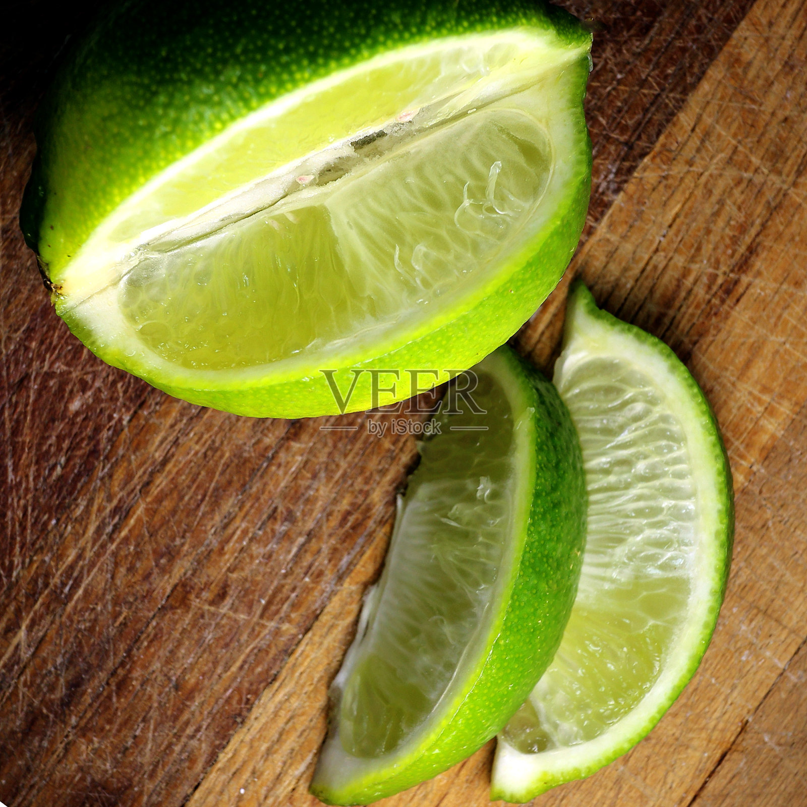 两块酸橙放在砧板上,变成棕色照片摄影图片