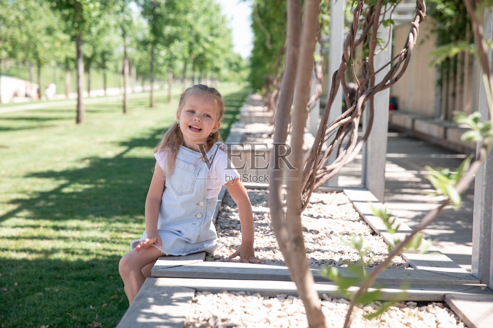 城市背景下的小女孩对着镜头微笑。照片摄影图片