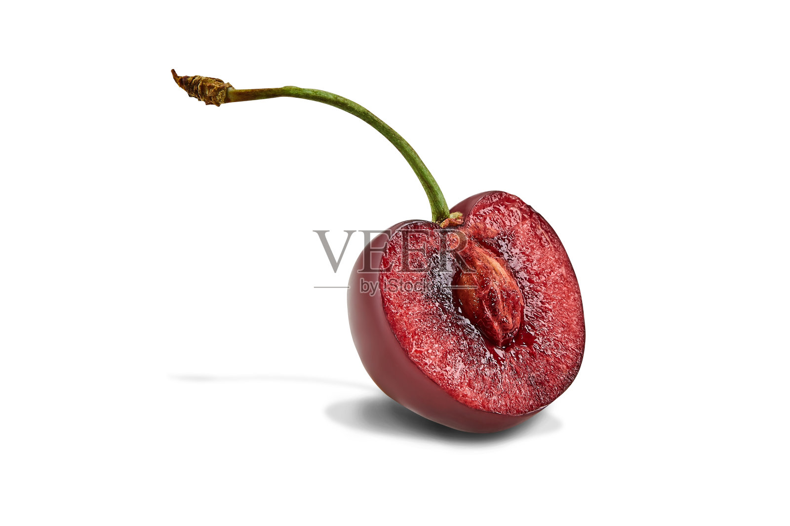 切成两半的红色甜樱桃,其核和茎在白色背景上分离。关闭,复制空间照片摄影图片