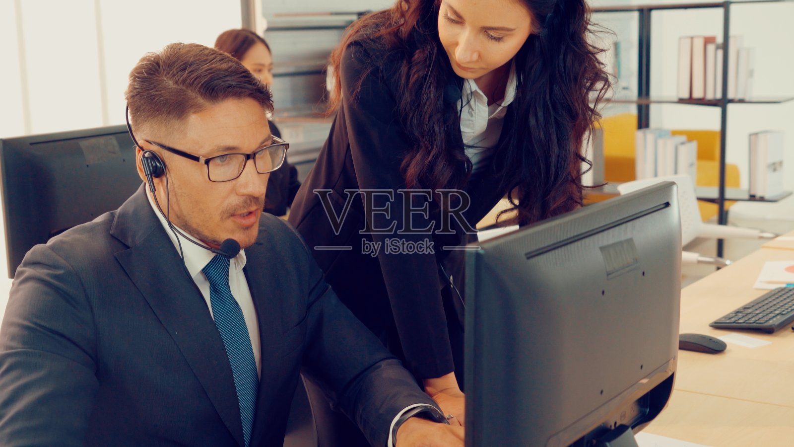 商务人员戴着耳机在办公室工作照片摄影图片