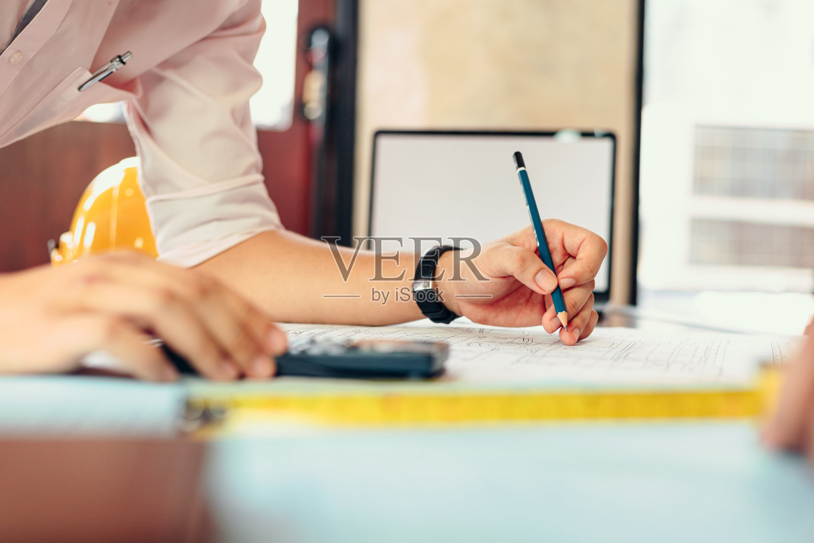 工程师们拿着一支笔指着一座建筑,并绘制出施工计划,为建筑商提供详细的指导。负责工程设计和图纸编写。照片摄影图片