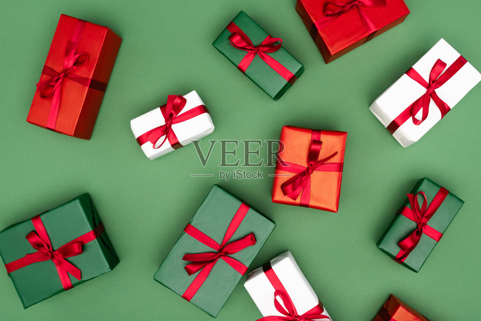 俯视图的多色礼品盒红色丝带在绿色背景照片摄影图片