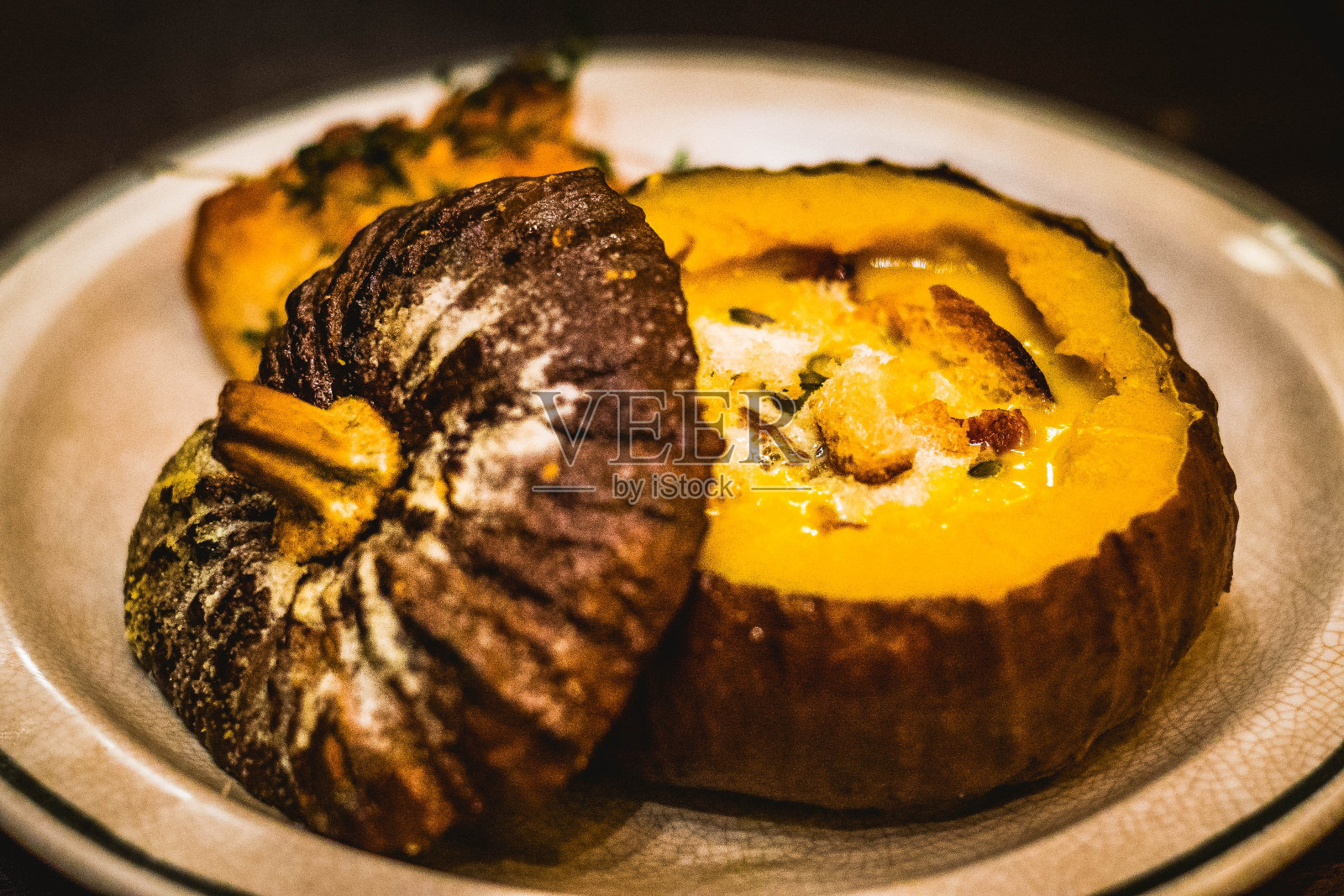 南瓜胡萝卜汤配上面包丁和烤法棍面包照片摄影图片