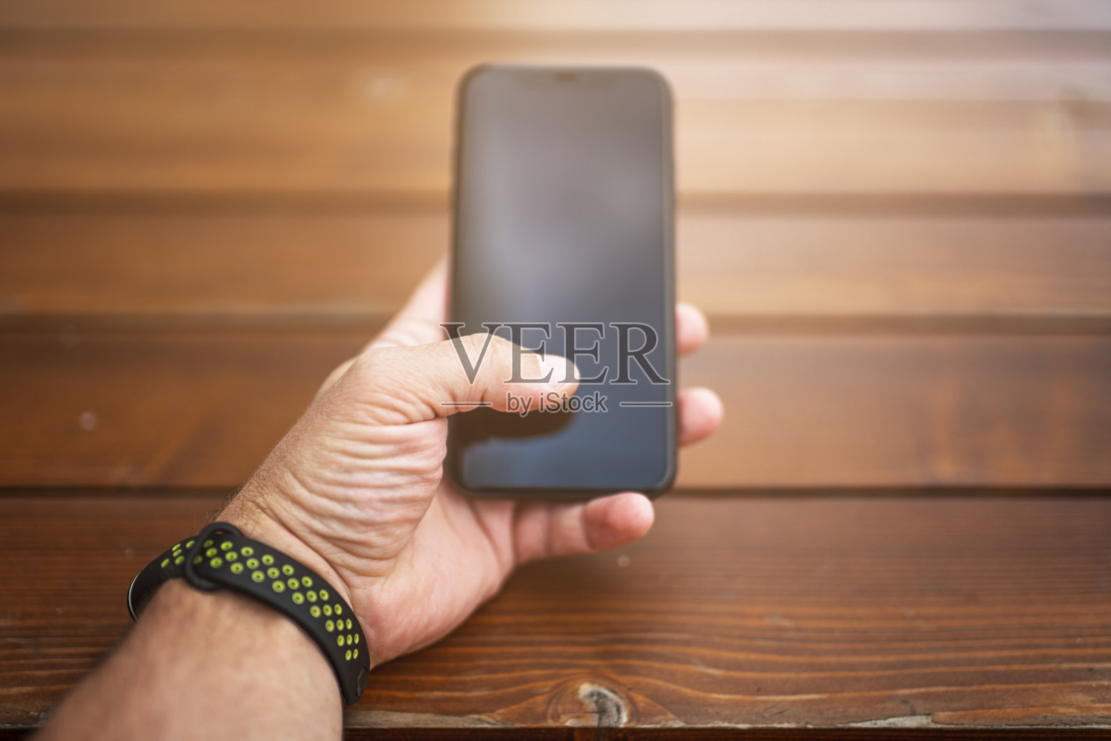 男性手与智能手机和木制背景照片摄影图片