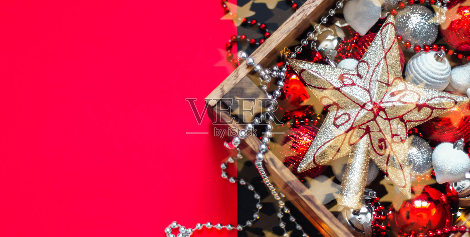 新年圣诞作文。五彩缤纷的圣诞玩具装在木盒里。圣诞星,圣诞红、银、白装饰照片摄影图片