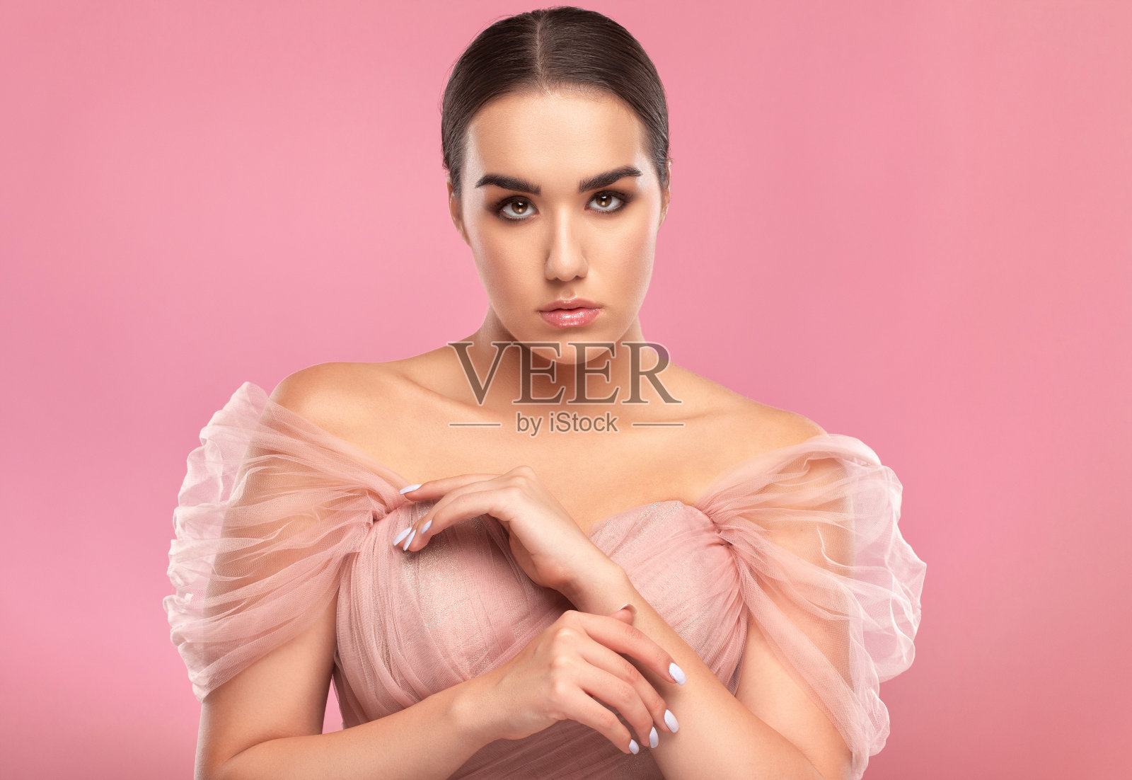 一个迷人的女孩的肖像与精致的化妆,郁郁葱葱的眉毛与脸部附近的一块布。看着摄像机。个人护理、美容和化妆概念。照片摄影图片