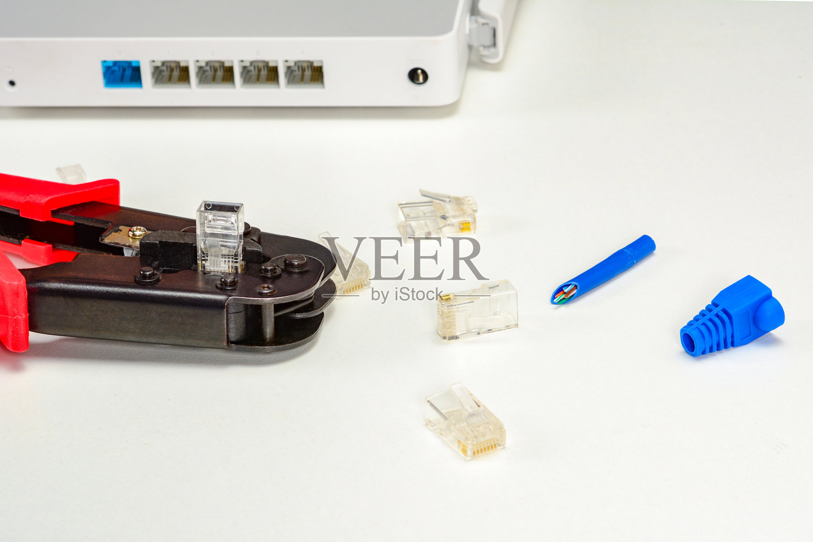 压接工具,互联网Wi-Fi路由器,RJ45连接器,蓝色boot for rj-45插头用于家庭互联网连接。家庭网络概念,特写。照片摄影图片