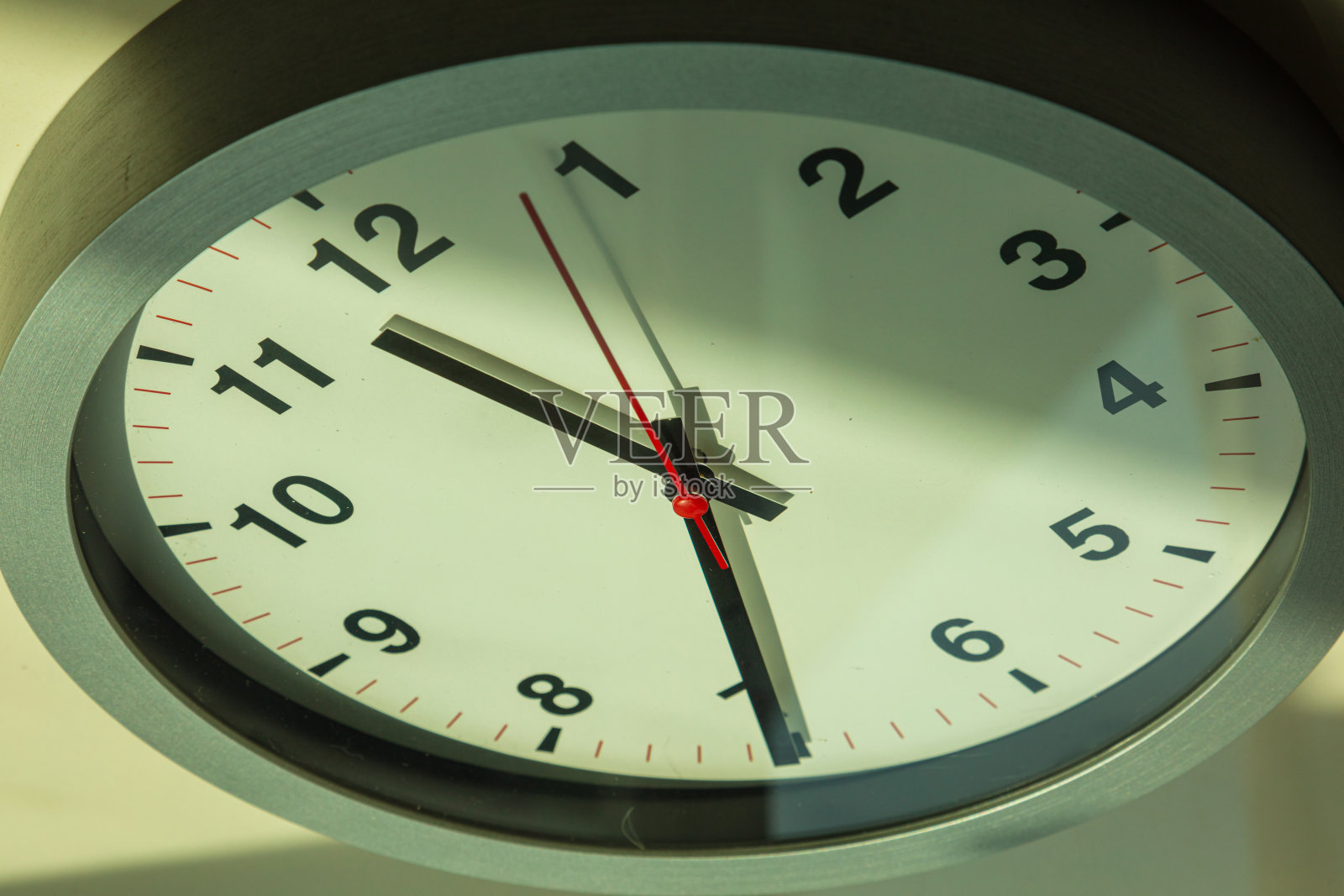 靠近一个挂钟,上面有一个红色的秒针。照片摄影图片