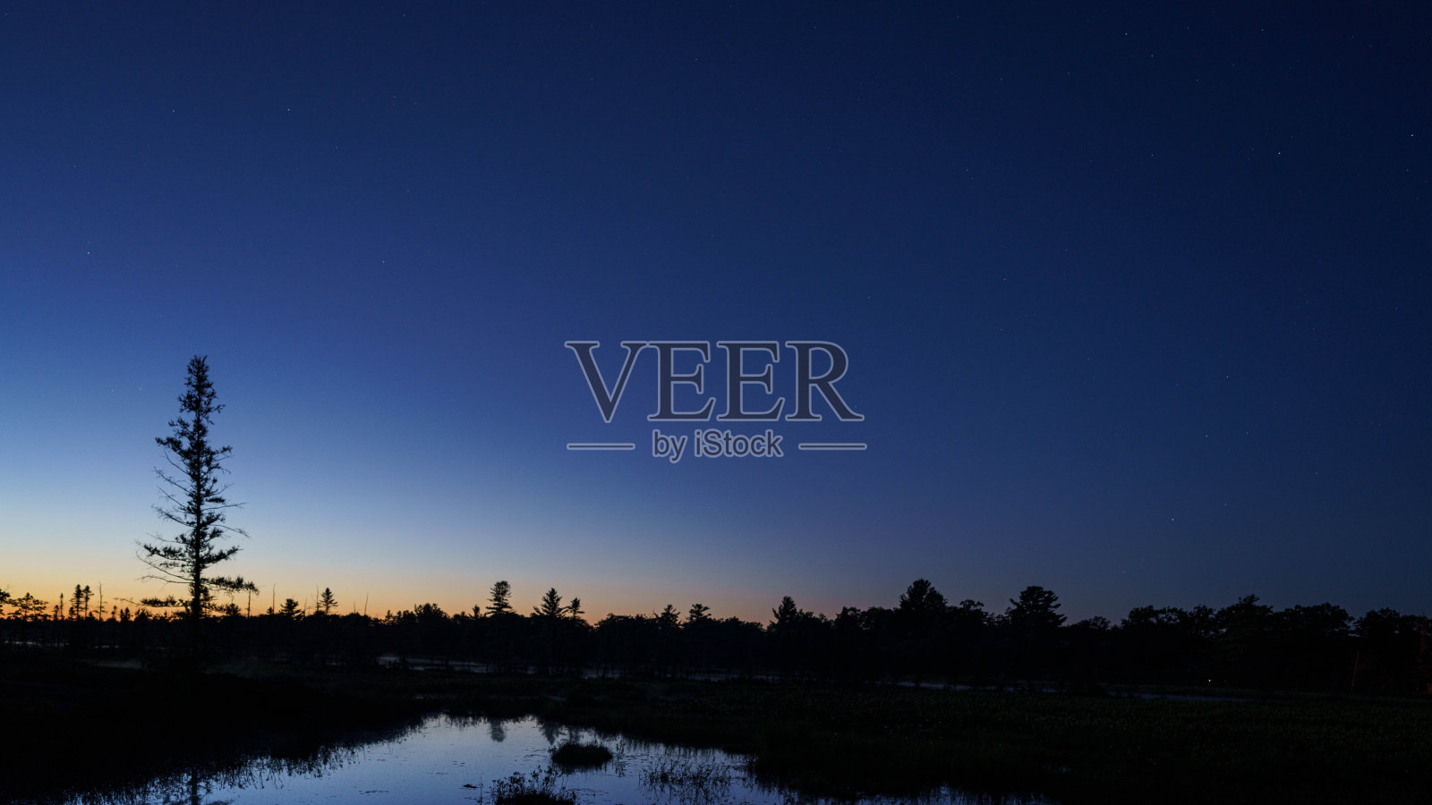 加拿大安大略省托伦斯黑暗天空保护区的夏夜天空中,银河和星星倒映在平静的湖面上照片摄影图片