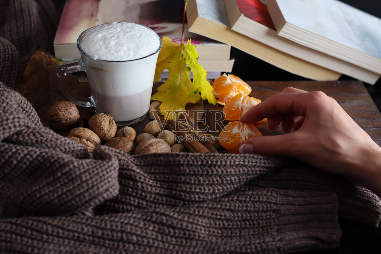 女性手从装饰过的秋概念桌上拿起橘果照片摄影图片