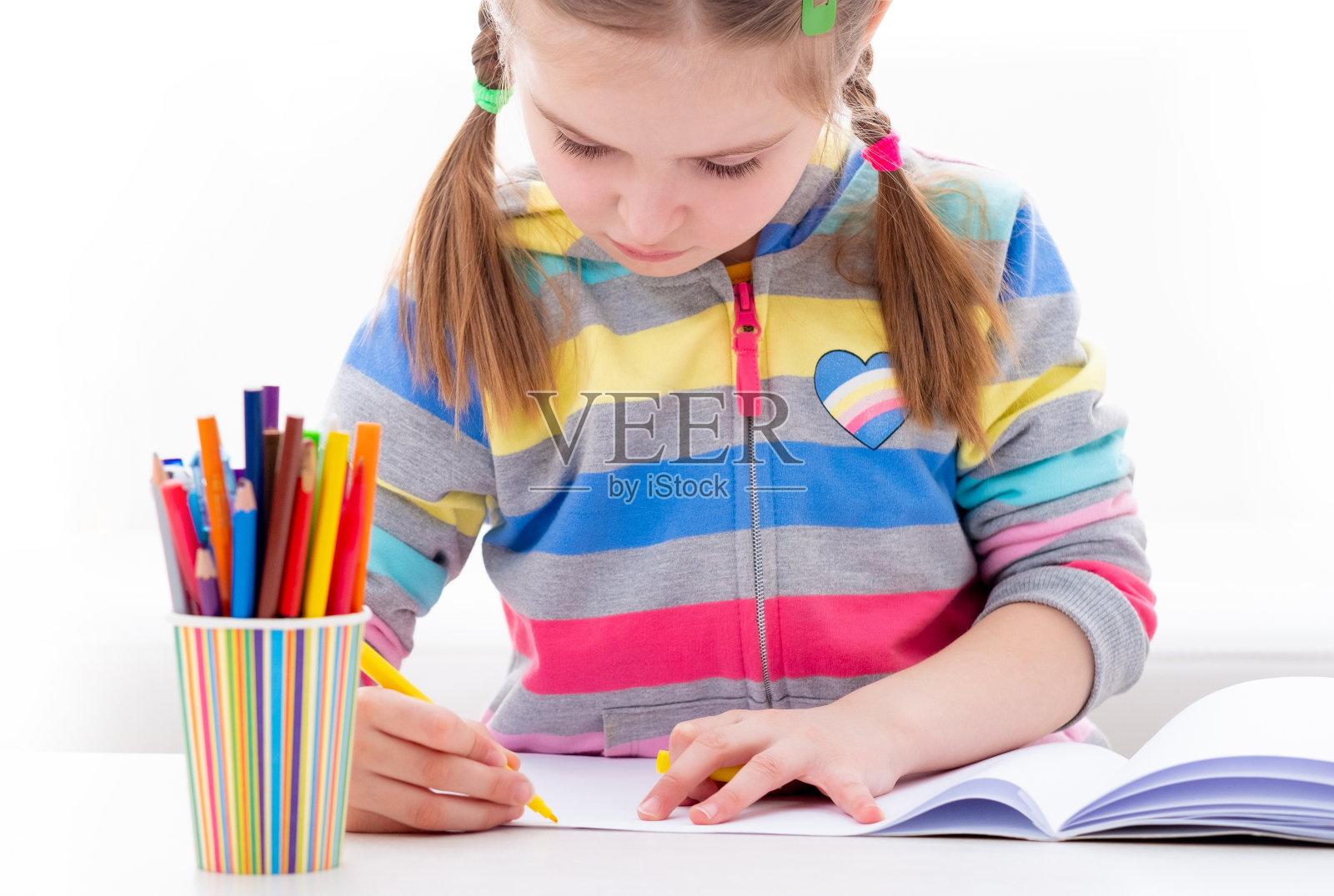 女学生在她的学习书上涂色照片摄影图片