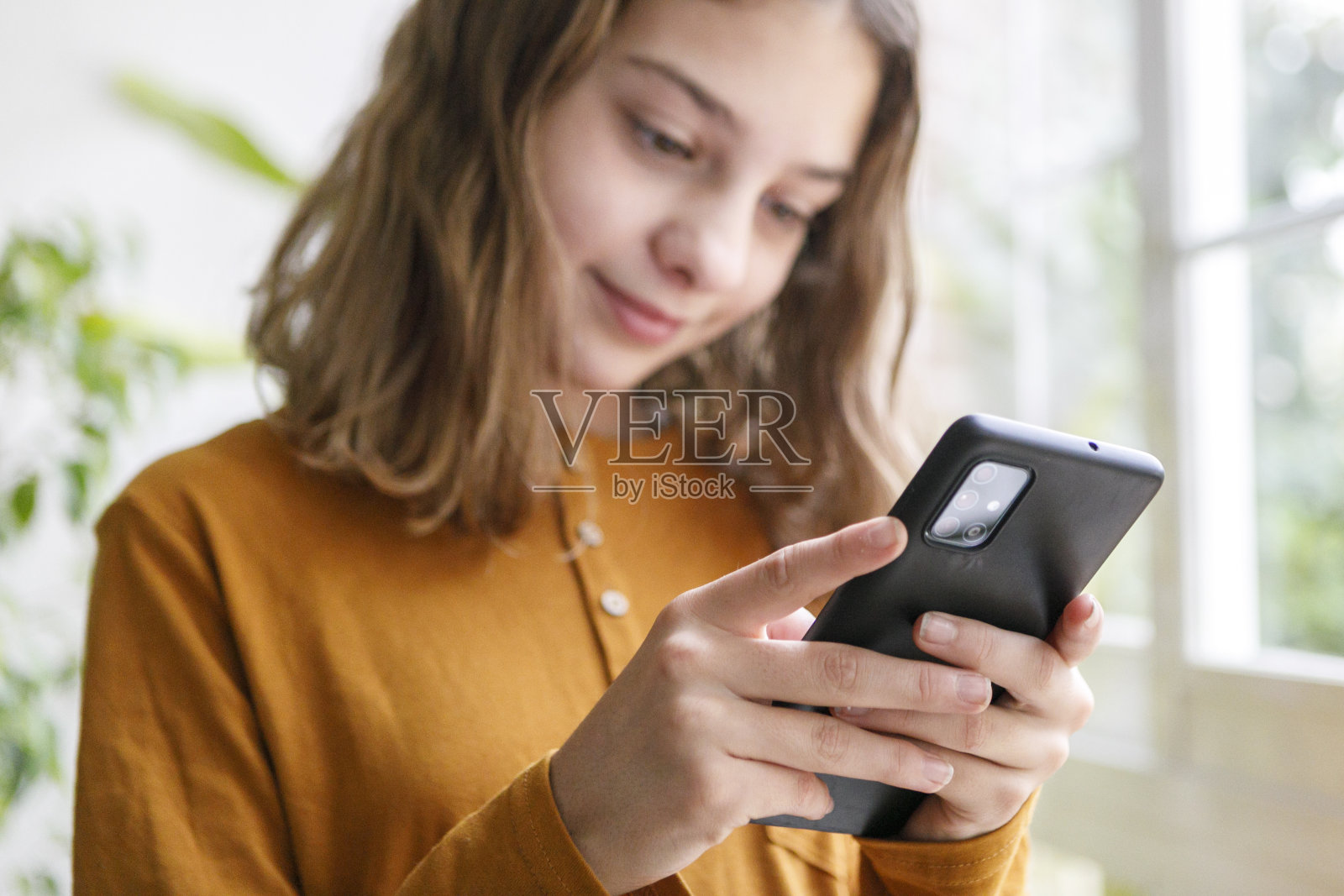 小女孩在家里用手机自拍。Z代概念使用技术照片摄影图片