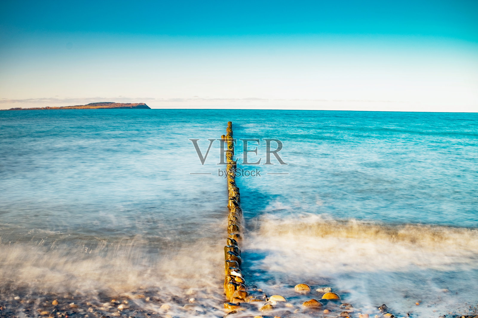 傍晚波罗的海和木制防波堤。照片摄影图片