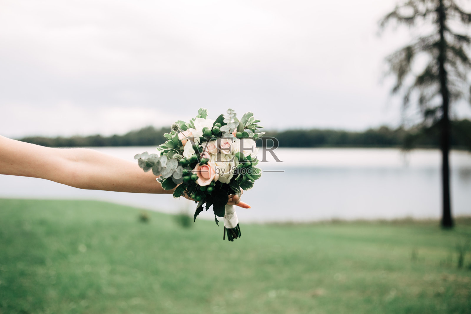 穿着婚纱的新娘手中捧着花束照片摄影图片