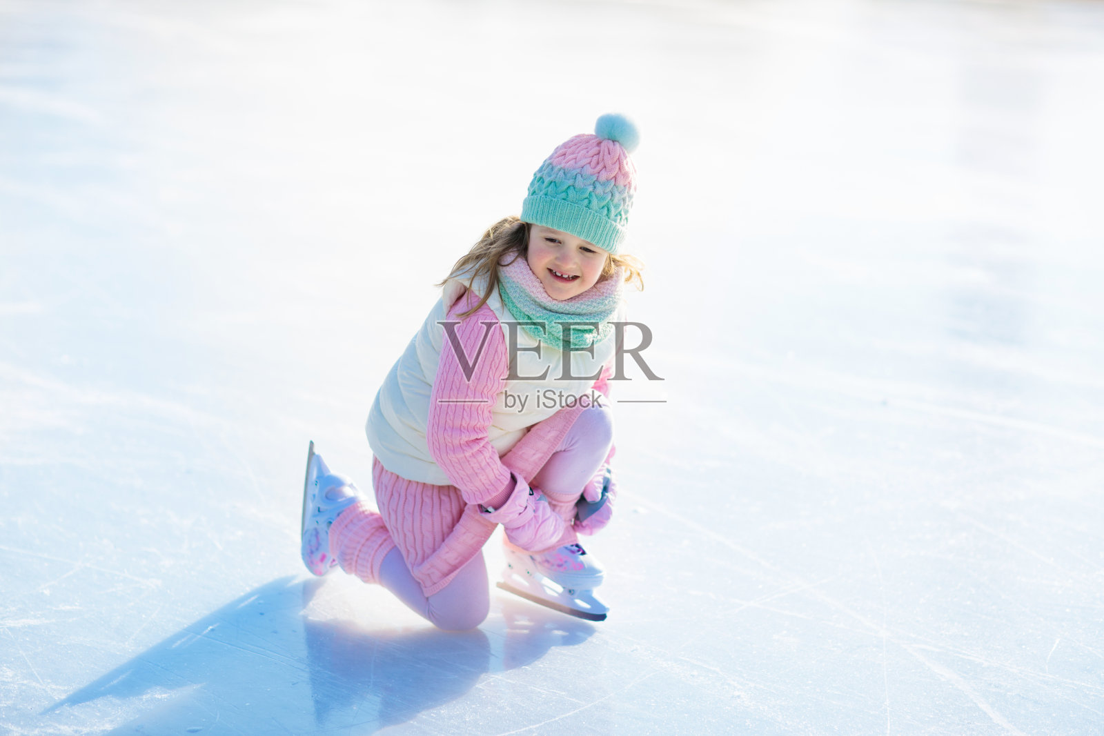 孩子们在天然冰上滑冰。孩子们溜冰鞋。照片摄影图片