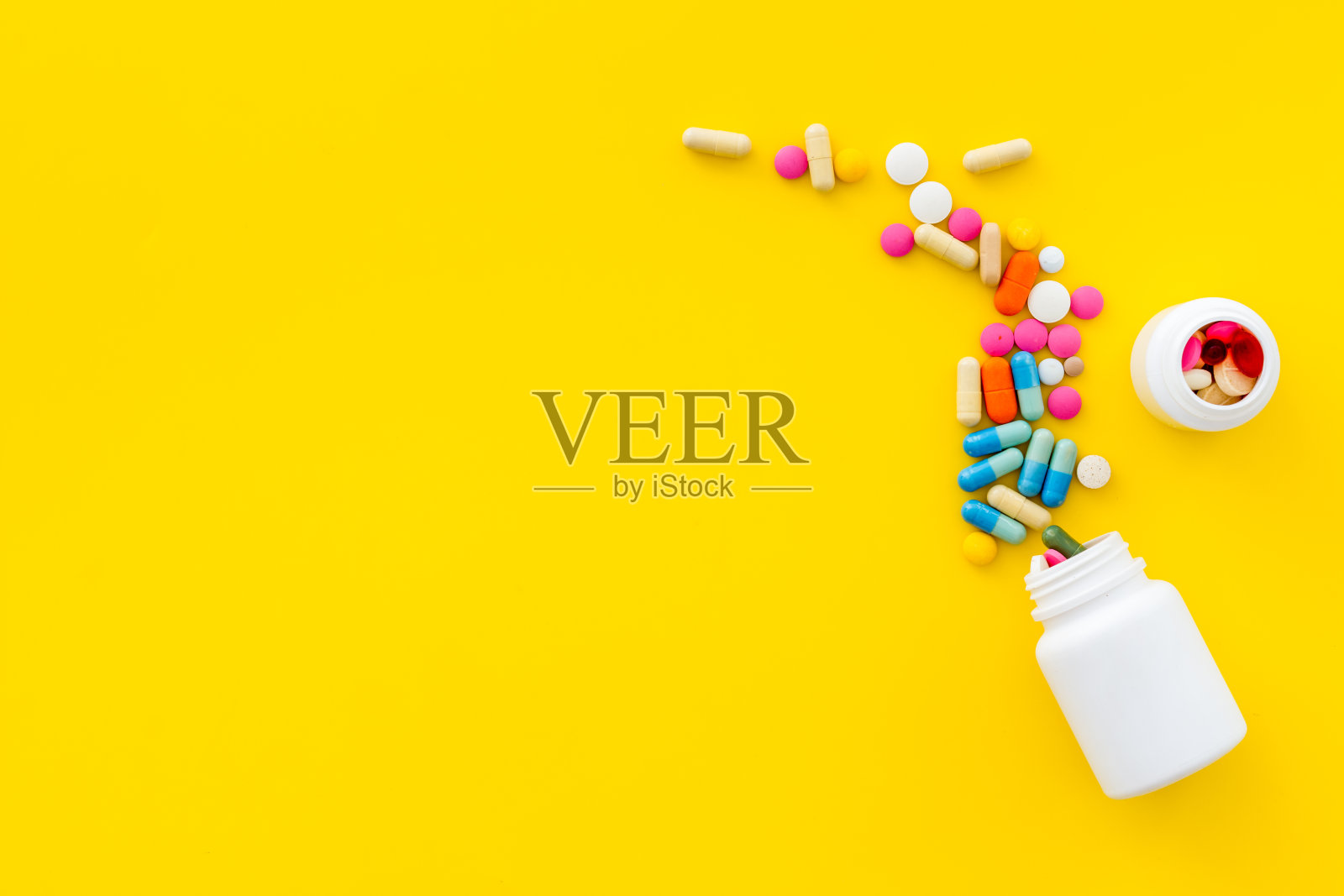 一堆药丸和上面的药瓶照片摄影图片