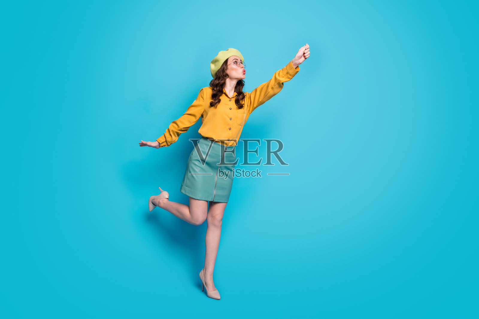 惊讶的女孩的全长照片牵手试着抓空气飞阳伞走穿好看的衣服鞋子孤立在蓝色背景照片摄影图片