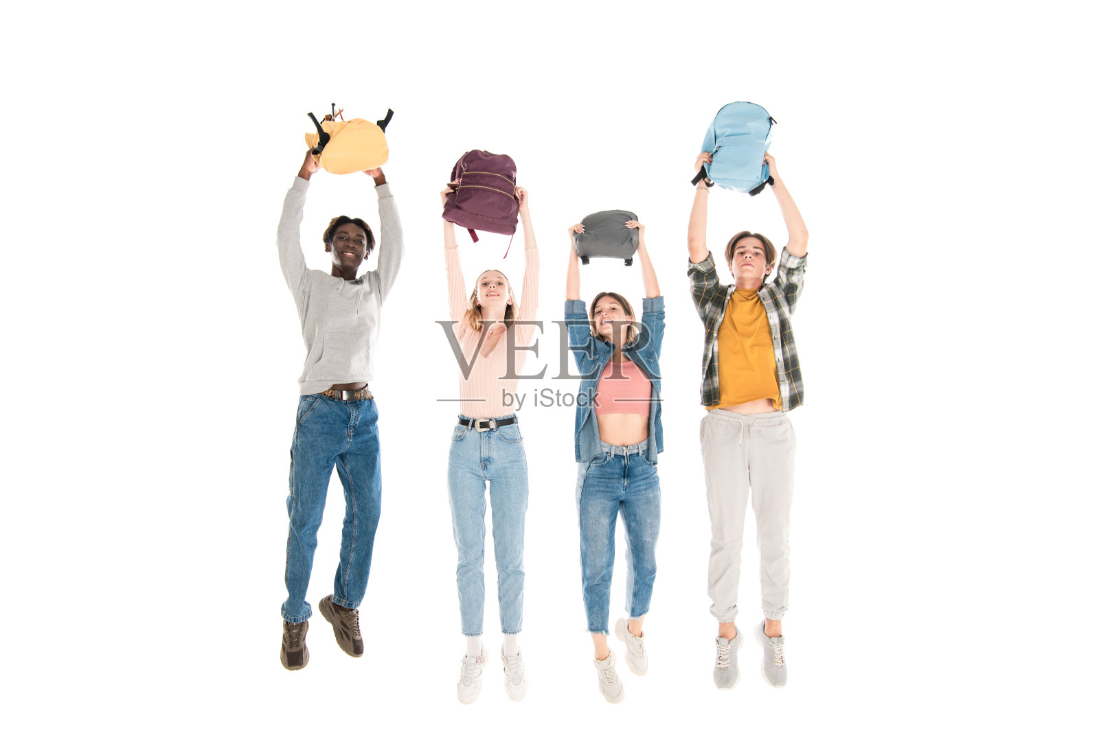 积极多元文化的青少年背着背包跳起来孤立在白人身上照片摄影图片