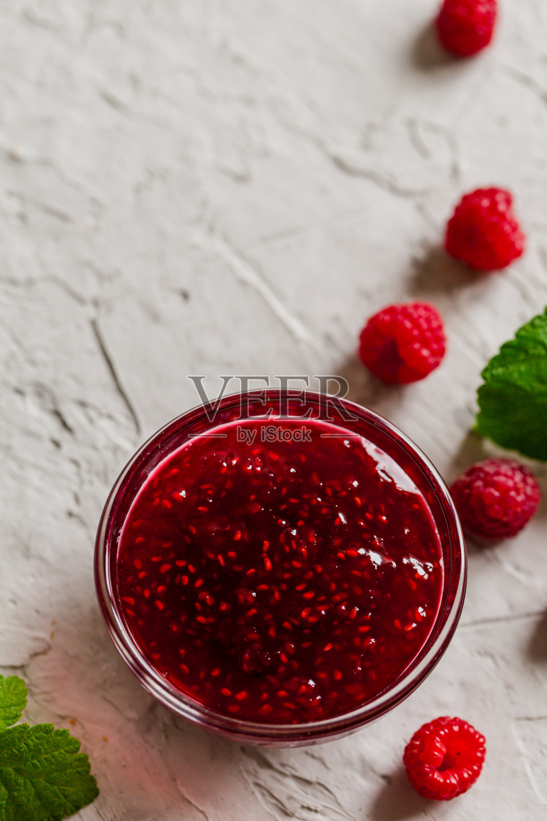 自制的覆盆子果酱在混凝土背景和新鲜的覆盆子,选择性的焦点照片摄影图片