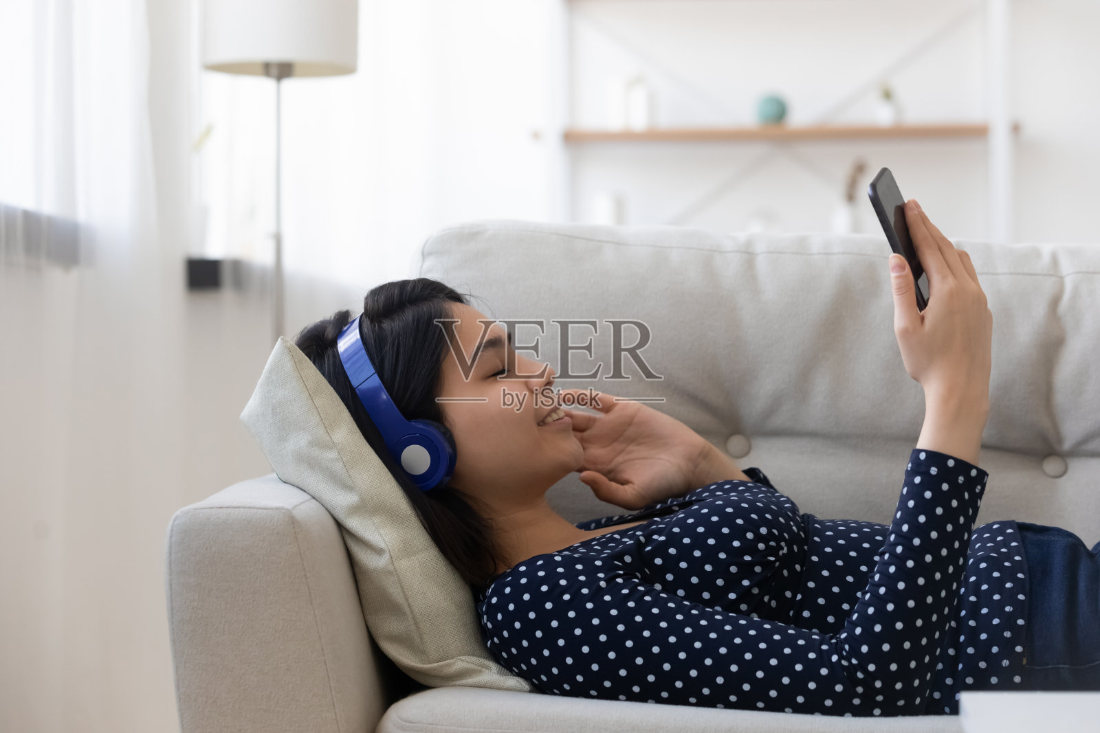 在沙发上放松听音乐的年轻亚洲女性照片摄影图片