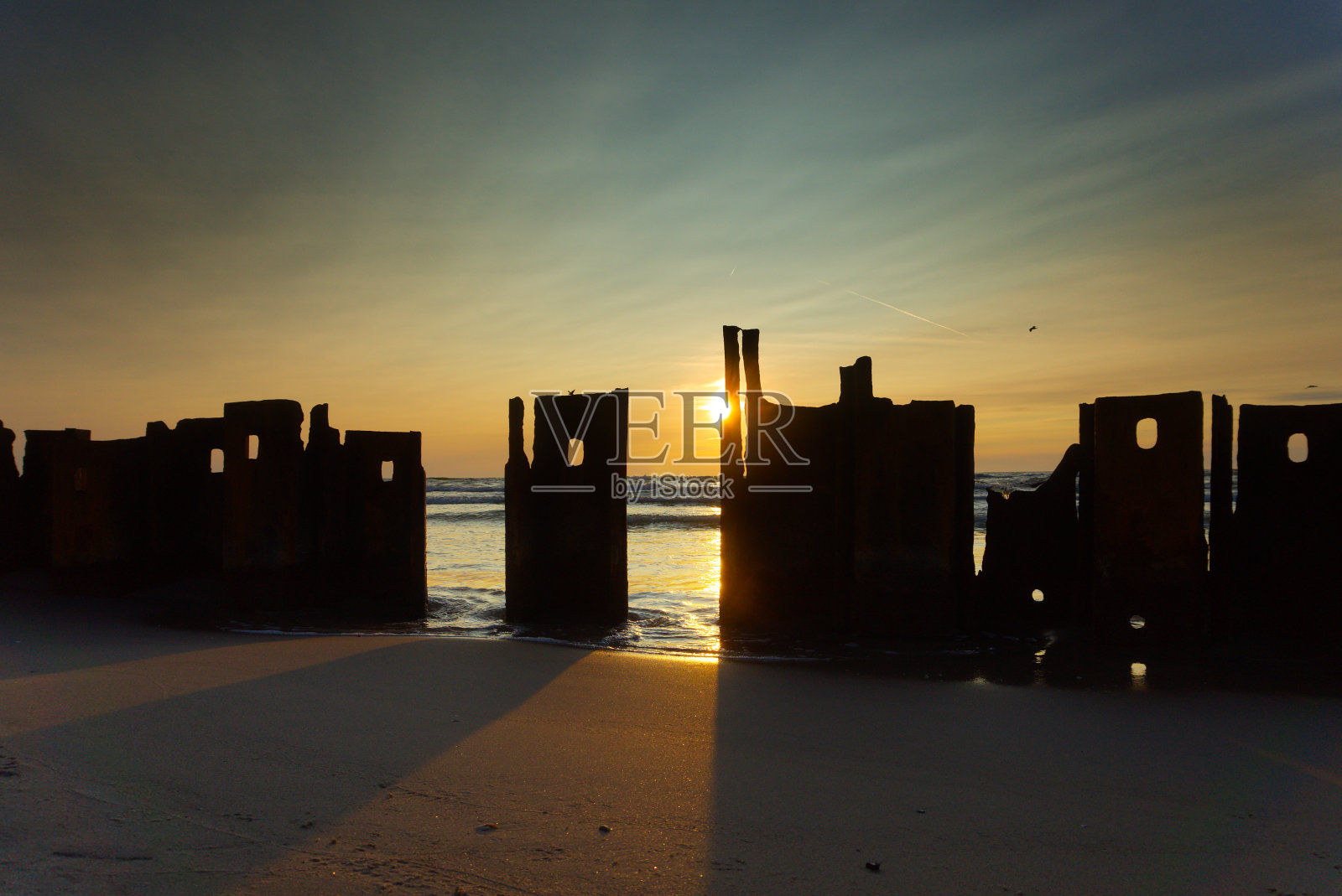 残垣断壁在海上夕阳的映衬下形成剪影照片摄影图片