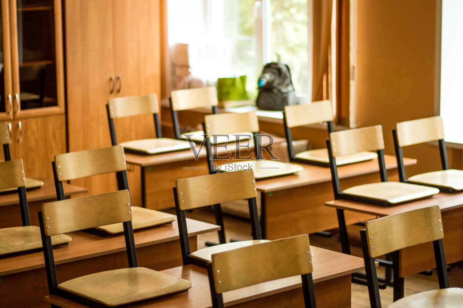 教室里空无一人,木椅立在课桌上照片摄影图片