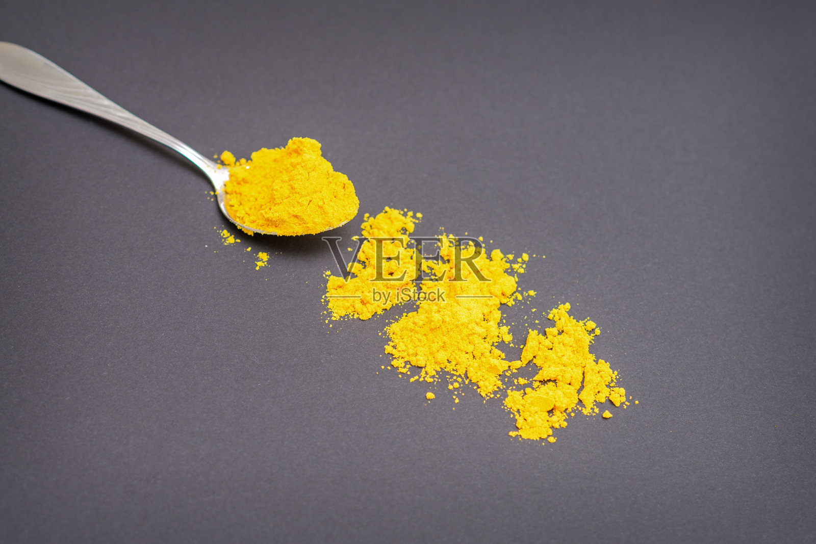 金属勺上的姜黄粉照片摄影图片