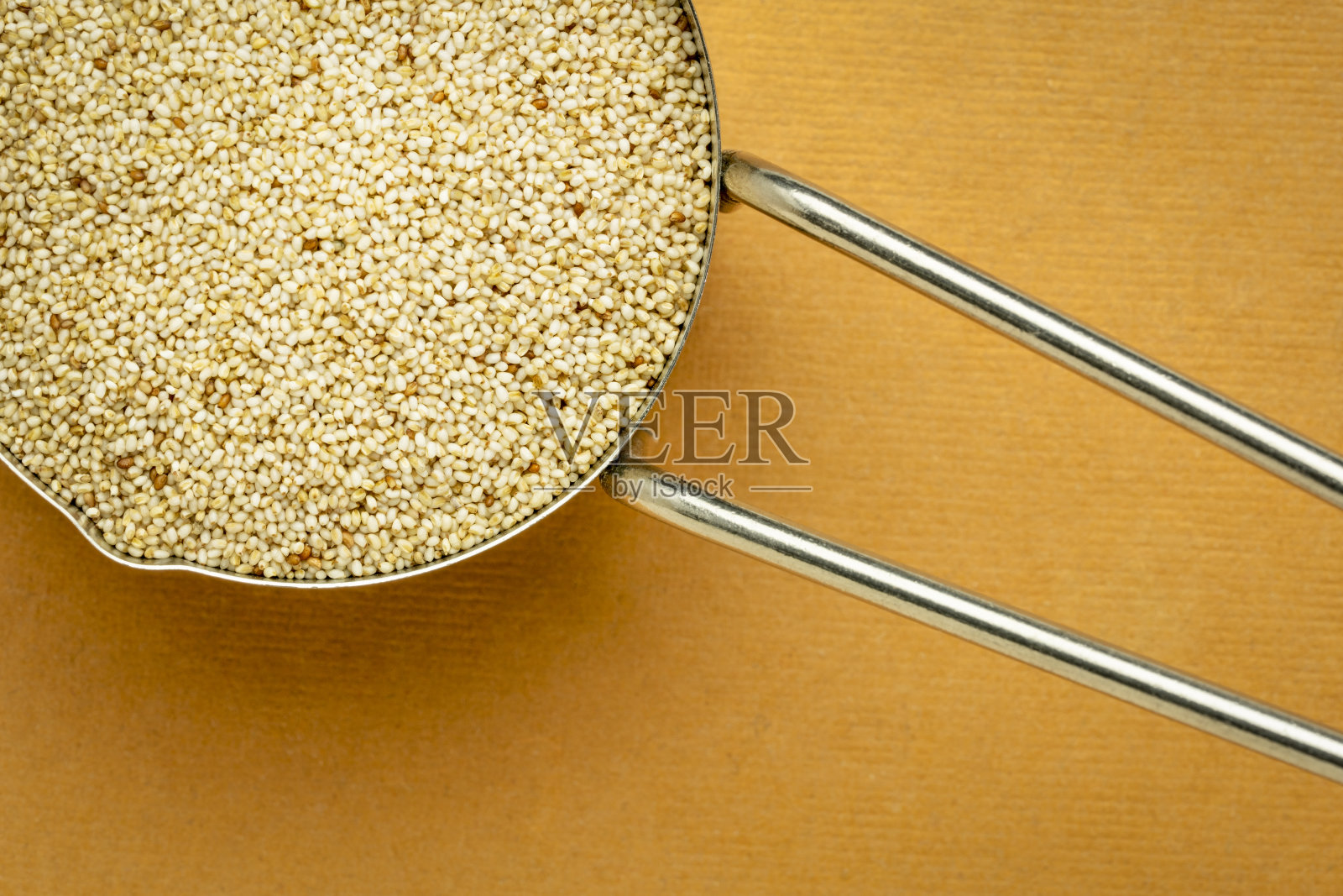 象牙苔麸颗粒在金属测量勺照片摄影图片