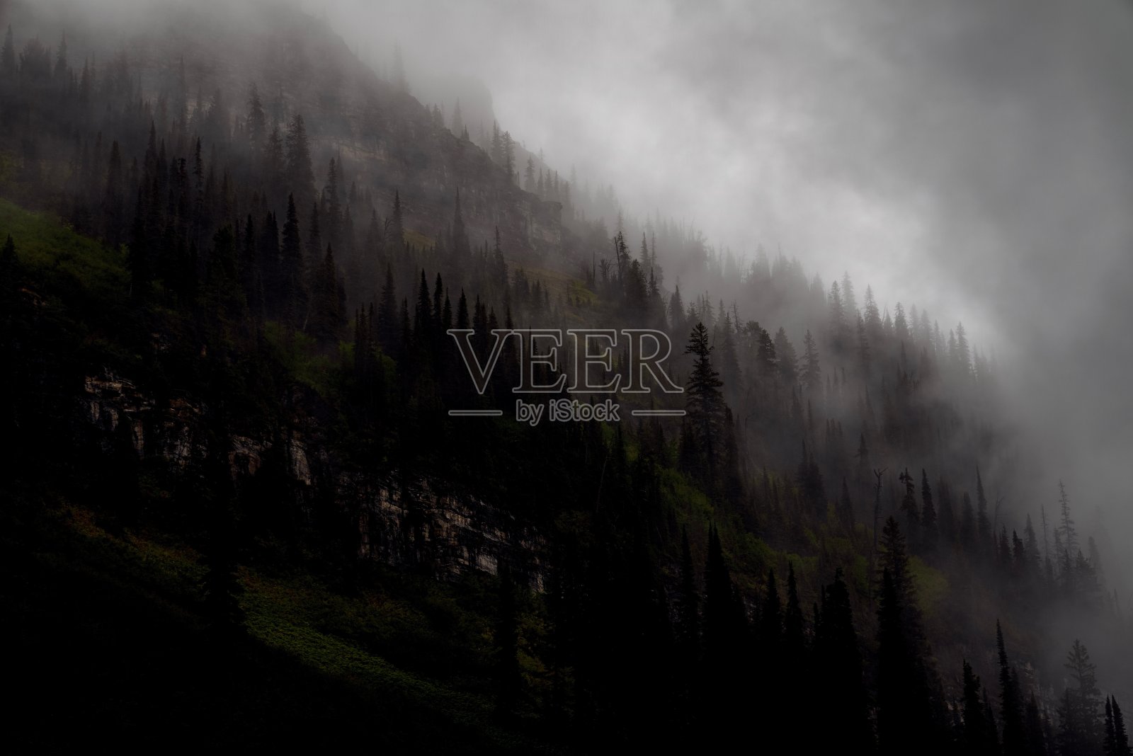 在美国蒙大拿州冰川国家公园的一个雨天,云层在群山中翻滚照片摄影图片