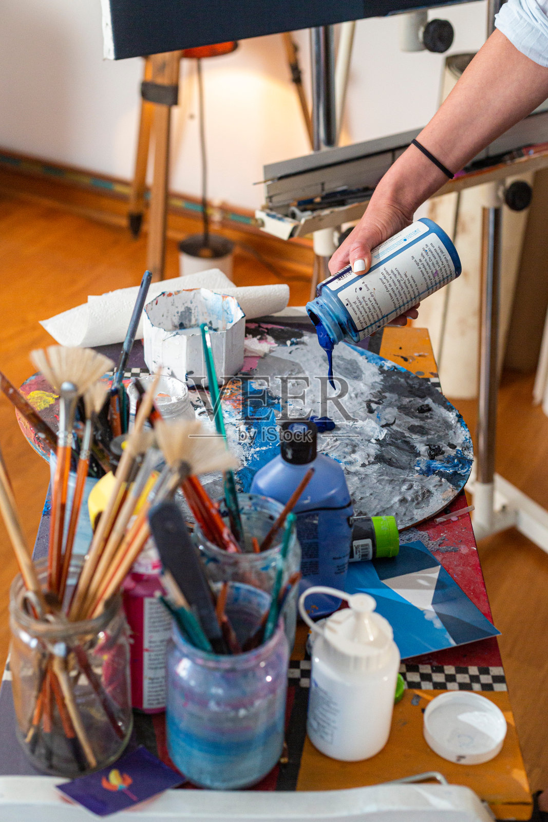 画家的手在调色板上挤压颜料的特写照片摄影图片