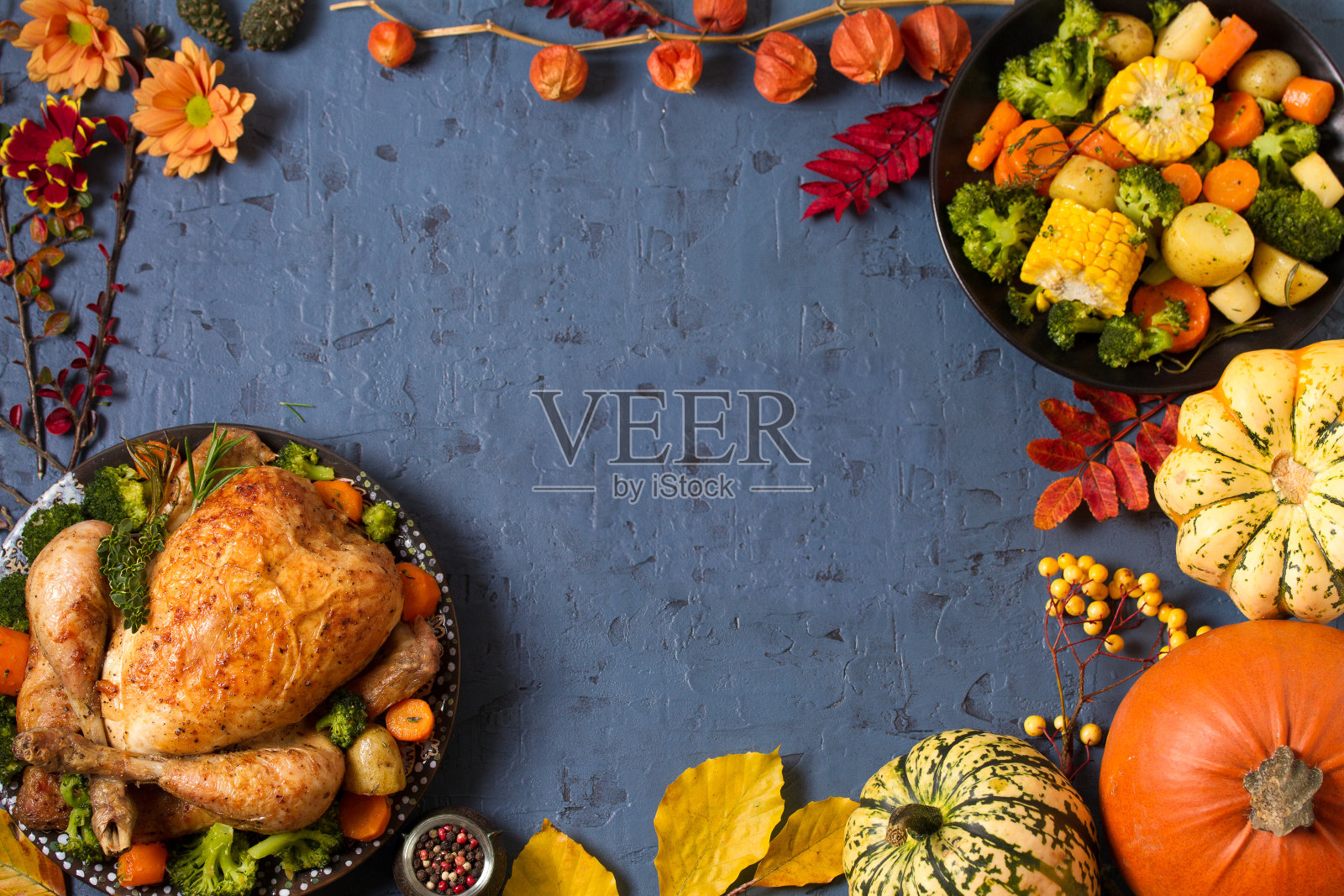 烤鸡或火鸡配蔬菜和南瓜。桌子上的秋饰。感恩节食品的背景照片摄影图片