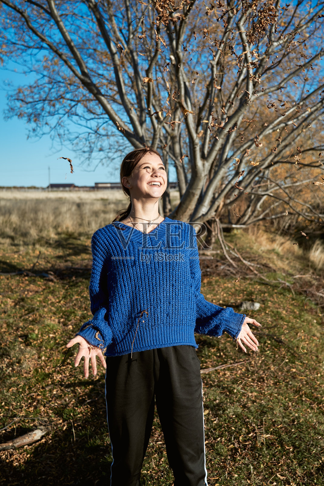 少女抛起秋天的落叶照片摄影图片