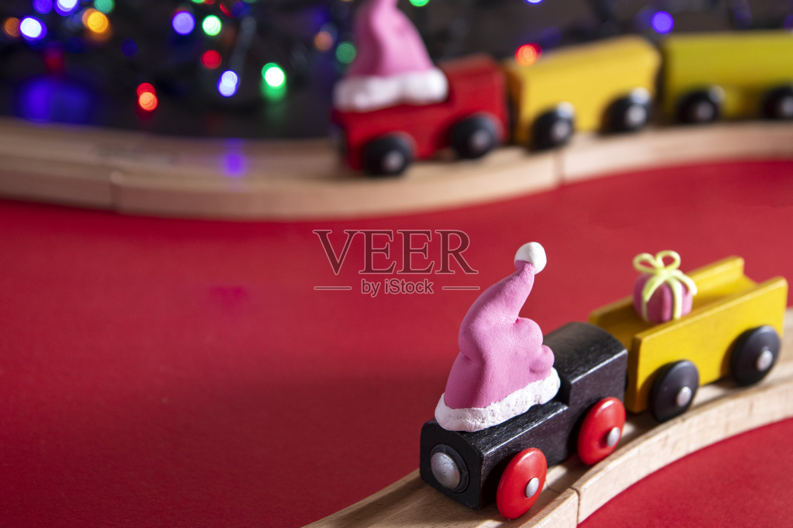 圣诞礼物递送:新年列车在圣诞老人的帽子在红色的背景与拷贝空间照片摄影图片