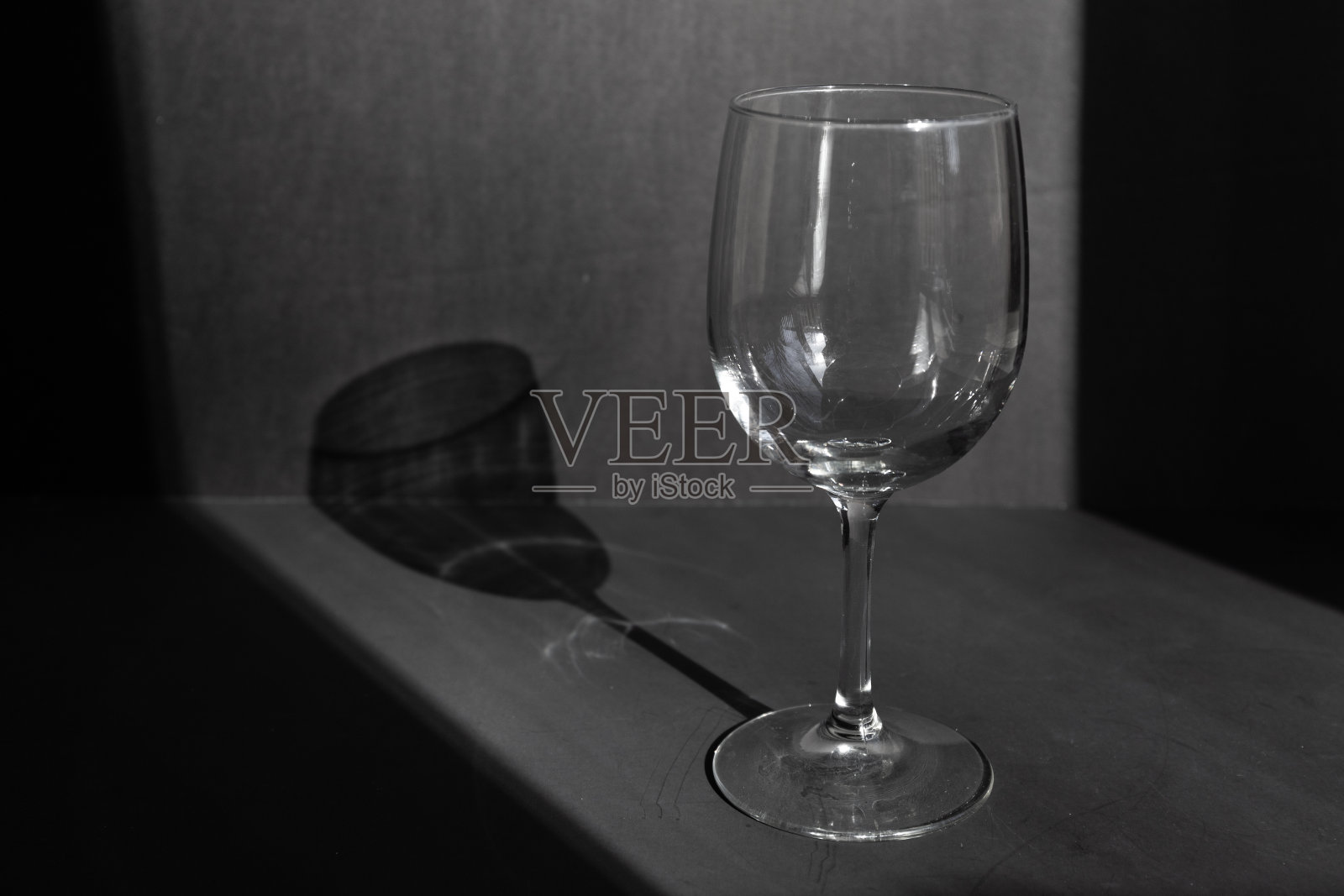 在一个黑色的背景上从空的葡萄酒杯的闪光和阴影照片摄影图片