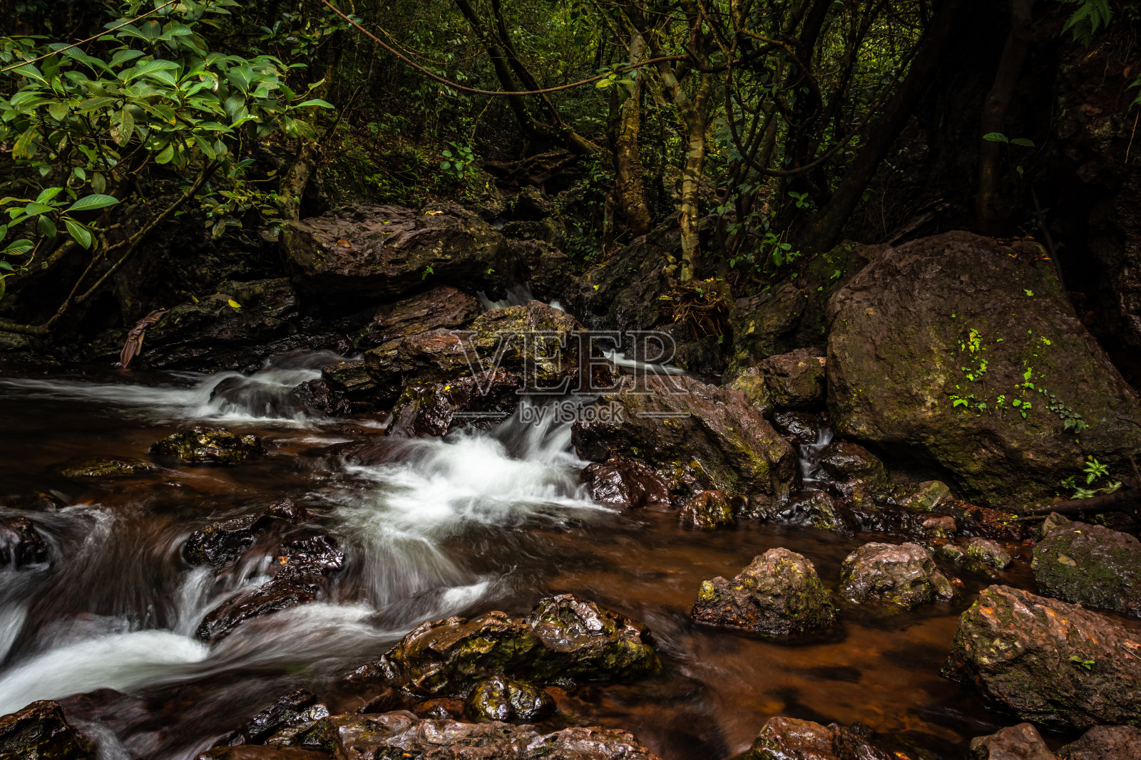 瀑布覆盖着郁郁葱葱的森林,长时间以平角暴露照片摄影图片