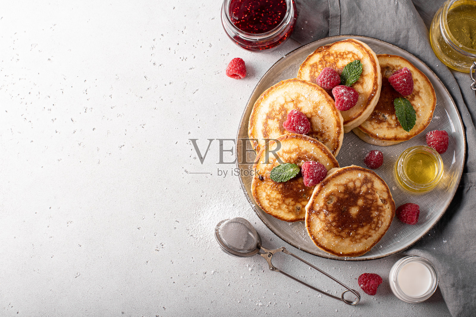 灰色盘子里放着自制的葡萄干和蜂蜜薄饼照片摄影图片