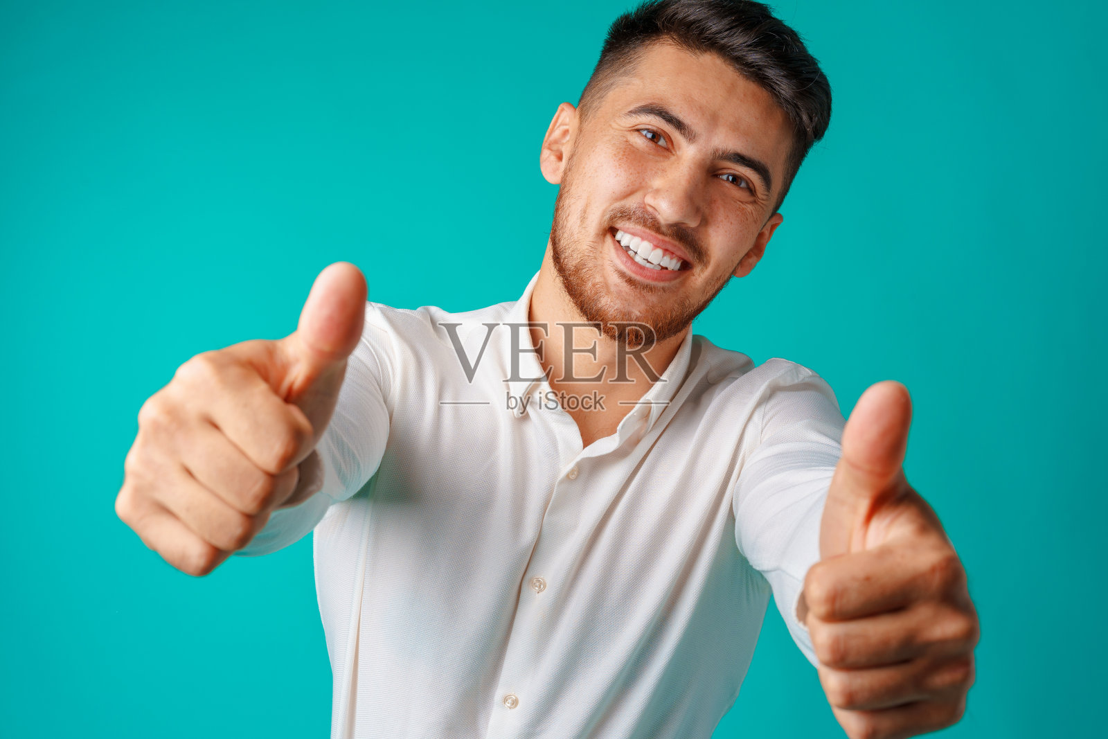 积极英俊的西班牙商人显示拇指向上的手势照片摄影图片