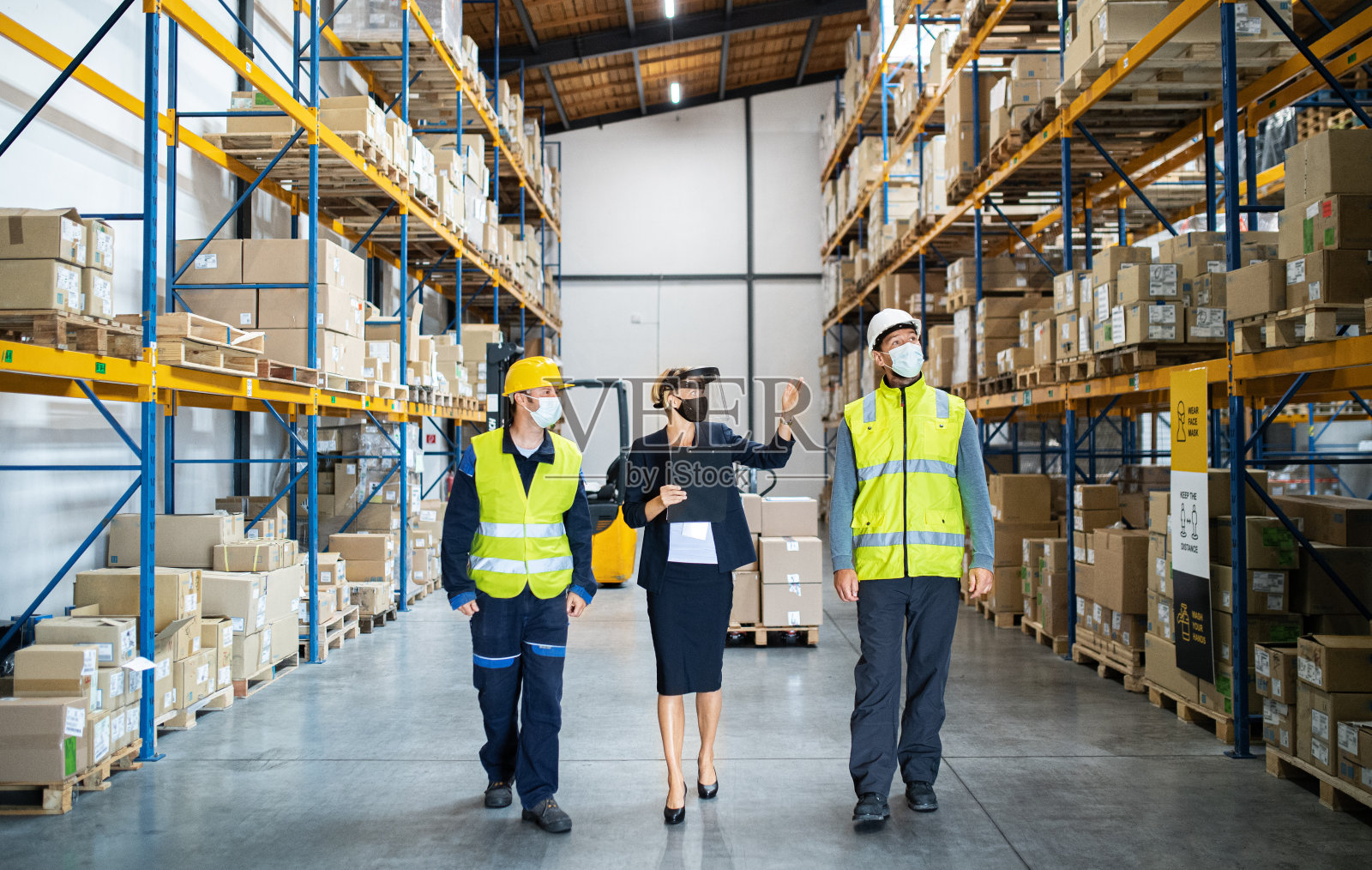 一组工人和经理在仓库室内工作,冠状病毒概念。照片摄影图片