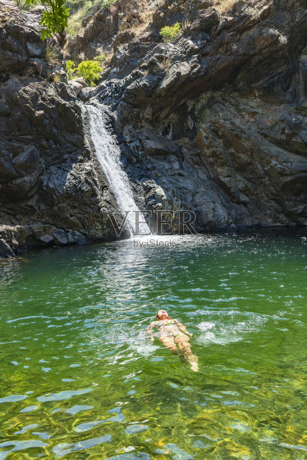 年轻女子在瀑布中游泳。土耳其穆格拉Koycegiz的极地瀑布。照片摄影图片