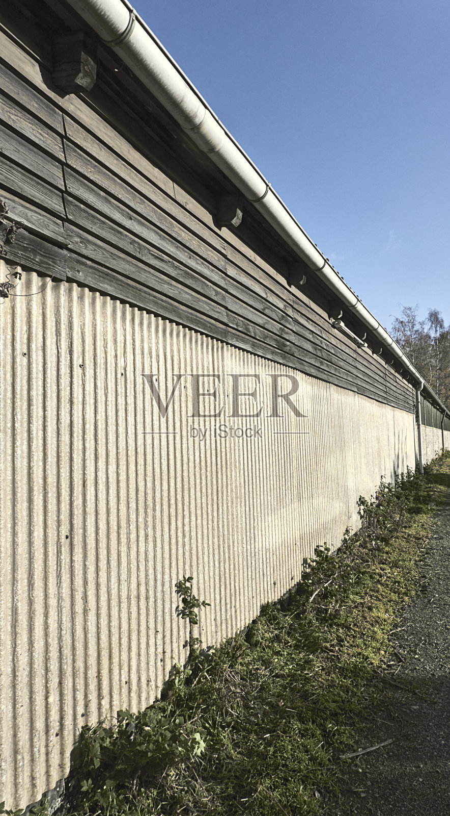 又长又高又丑的墙壁上有一条排水沟,在画面的末端集中在中央透视,抽象照片摄影图片