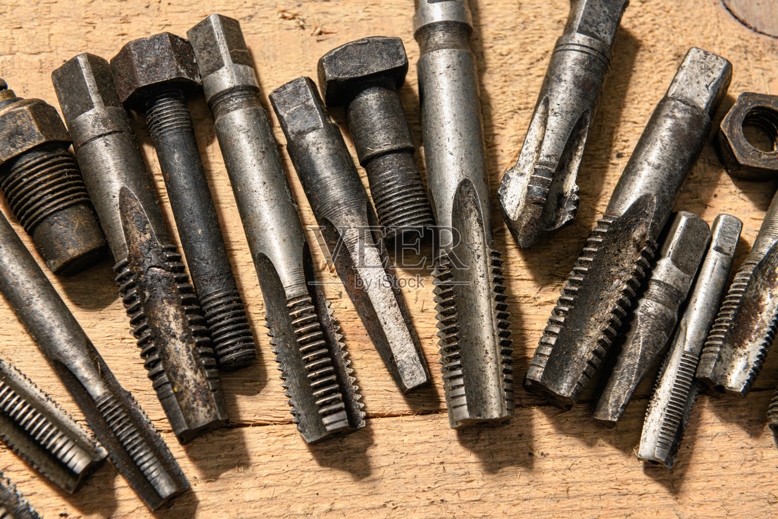 旧的手工工具-钻头和螺纹模具在一个木制的背景照片摄影图片