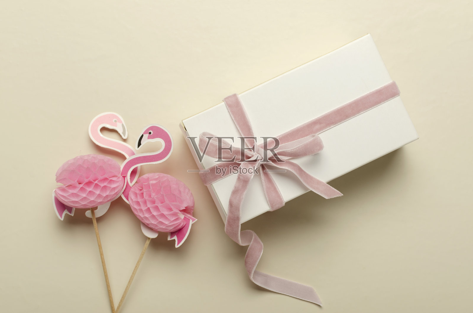 两个装饰火烈鸟和白色盒子的特写与粉红色的丝带在明亮的桌子上照片摄影图片